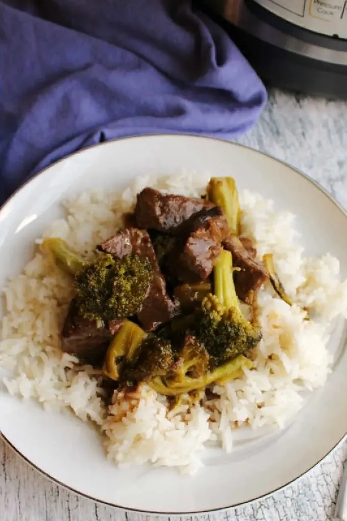 slices of slow cooker venison backstrap on top of broccoli and rice in white bowl 