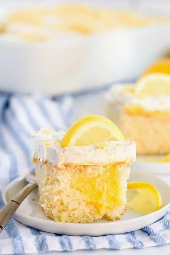 slice of lemon cake on white plate with silver fork 