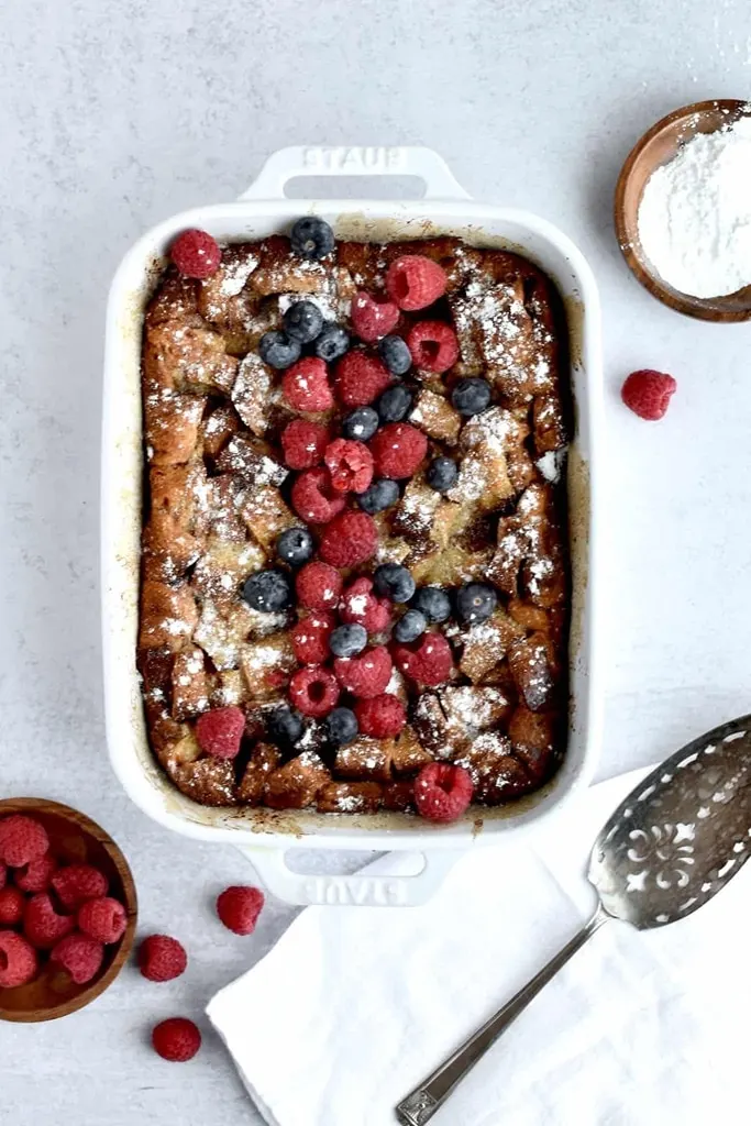 brioche toast casserole with berries on top in white dish 