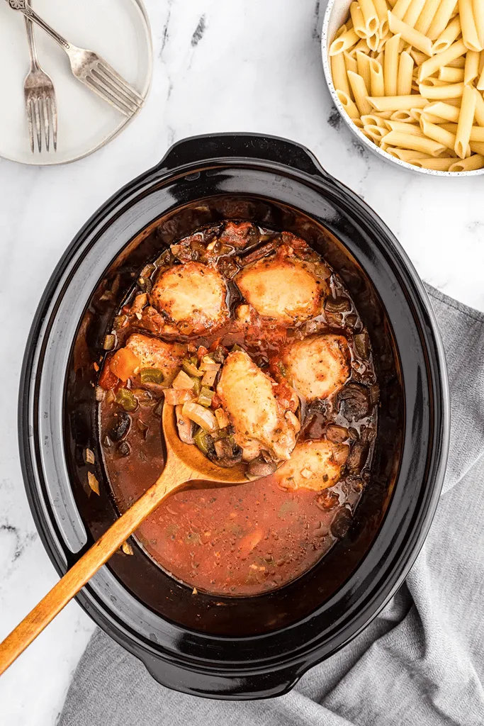 boneless skinless chicken thigh cacciatore in crockpot with diced tomatoes and pasta on side 