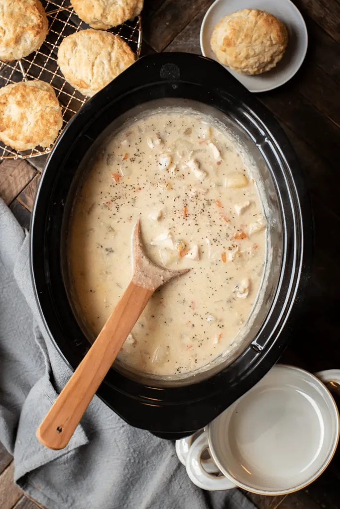 boneless skinless chicken thigh pot pie in slow cooker with biscuits on side 