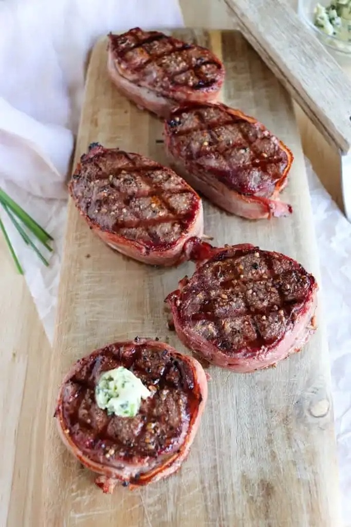 25 Venison Recipes You Will Love 18 bacon wrapped deer meat venison on wooden cutting board platter