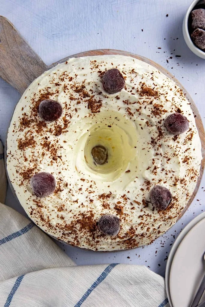 white forest bundt cake with cherries on top 