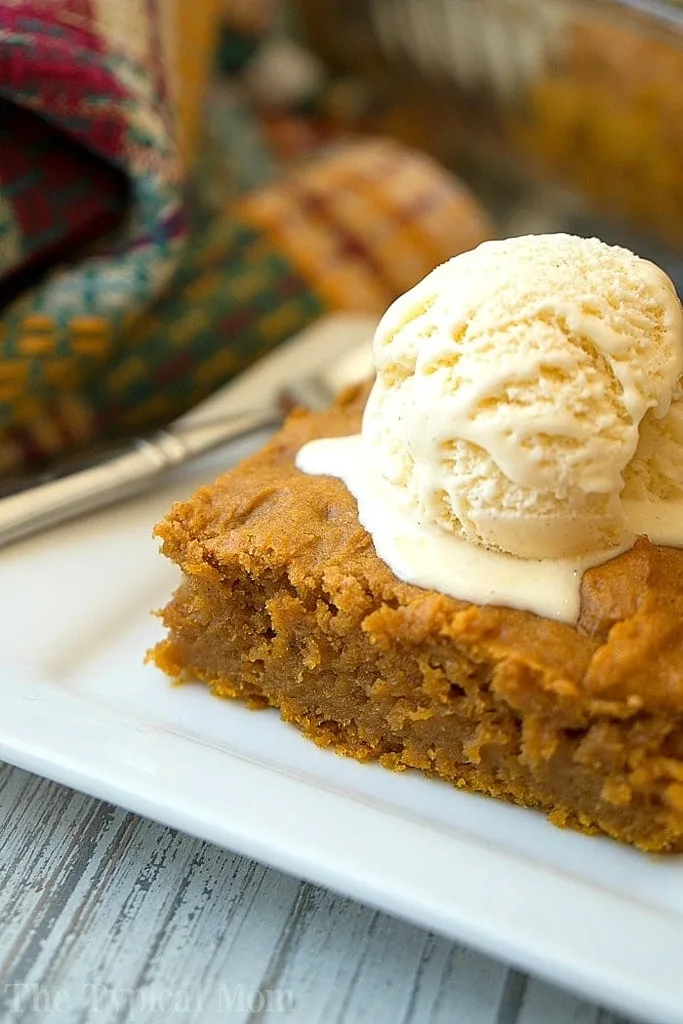 slice of pumpkin poke cake with scoop of ice cream on top 