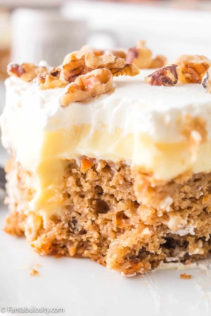 slice of carrot dessert with icing and walnuts on top 