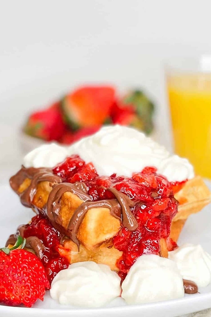 close up of strawberry short cake waffles with chocolate drizzle and strawberry puree 