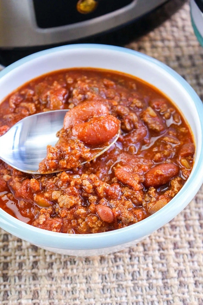 25 Venison Recipes You Will Love 4 bean and venison chili in white bowl with silver spoon