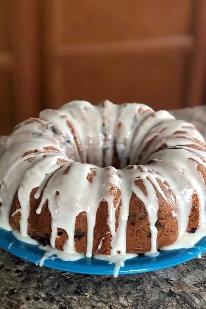 chocolate bundt cake with white icing on blue plate 