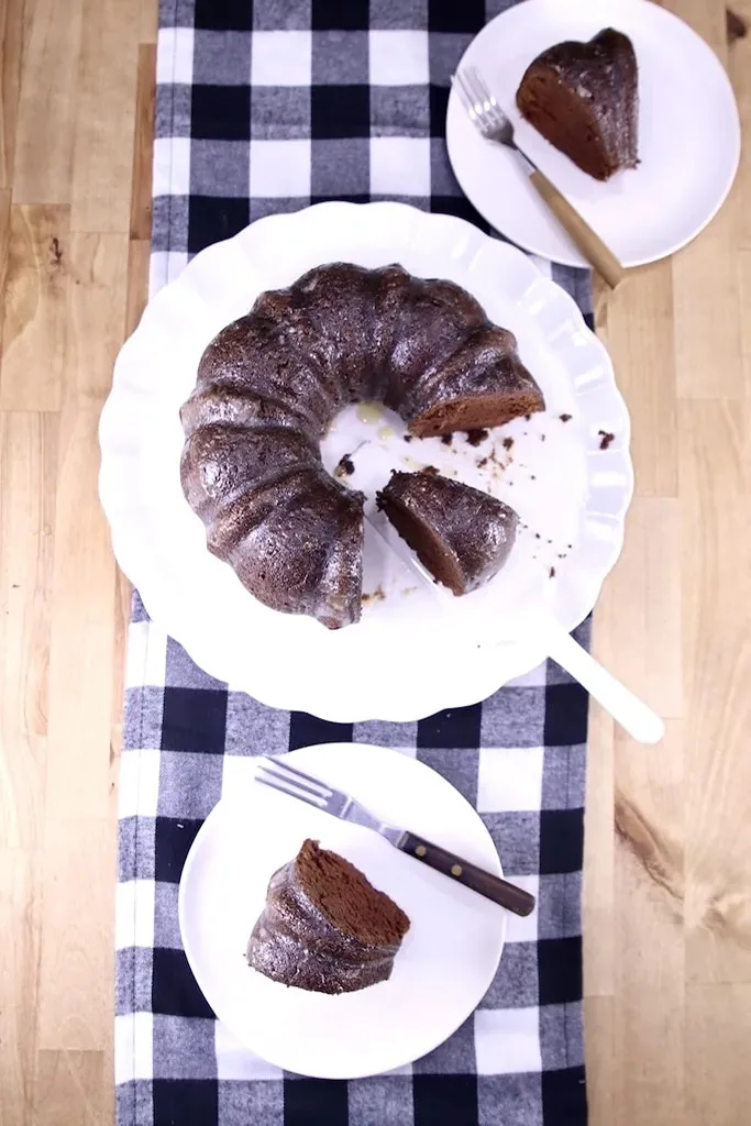 chocolate rum bundt cake on white plate with piece on white plate