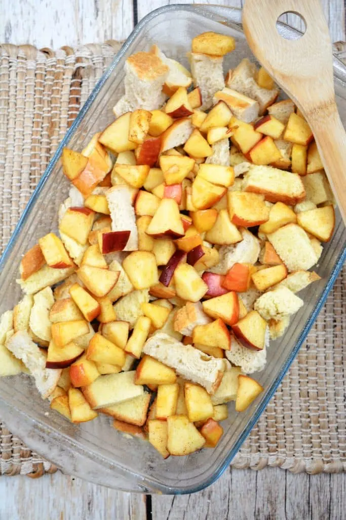 broken up bread pieces and chopped apples in glass baking dish 