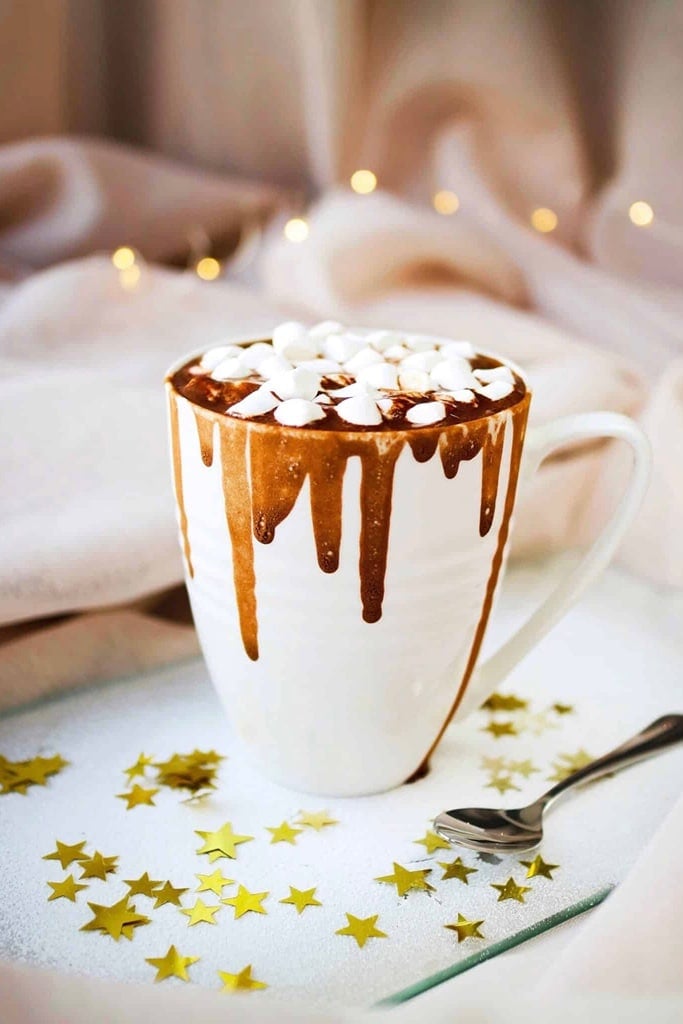 Slow Cooker Thanksgiving Recipes 21 creamy hot chocolate in white mug with chocolate drizzle topped with marshmallows