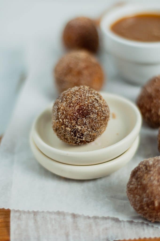 close up of a cinnamon sugar donut hole in small white plate