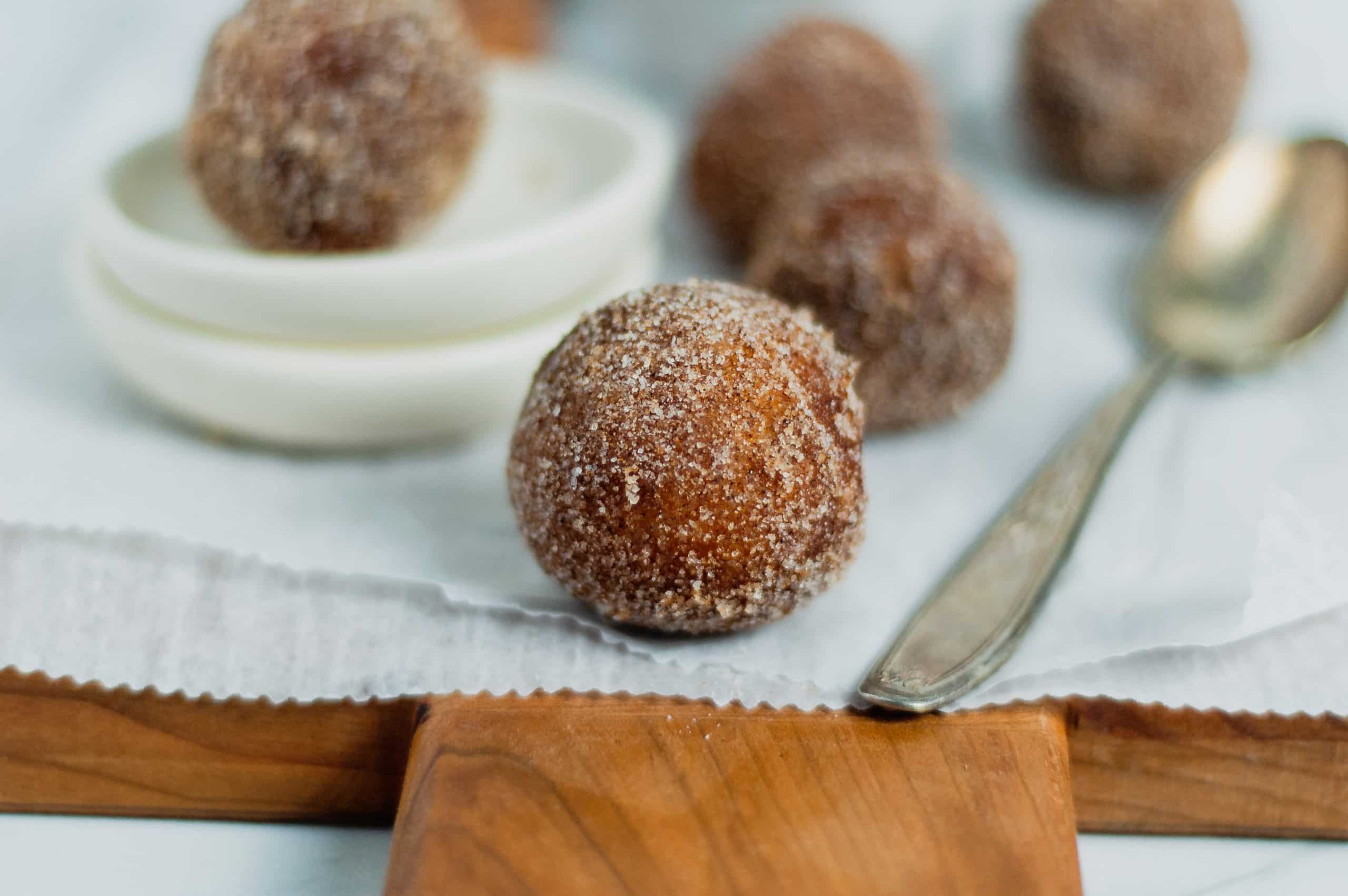 close up of cinnamon sugar donut hole on cutting board