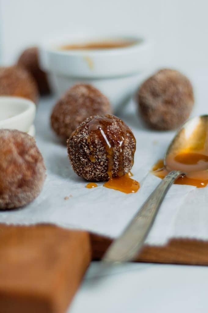 Cinnamon Sugar Donut Holes 12 close up of cinnamon sugar donut hole with drizzle on it and spoon on side