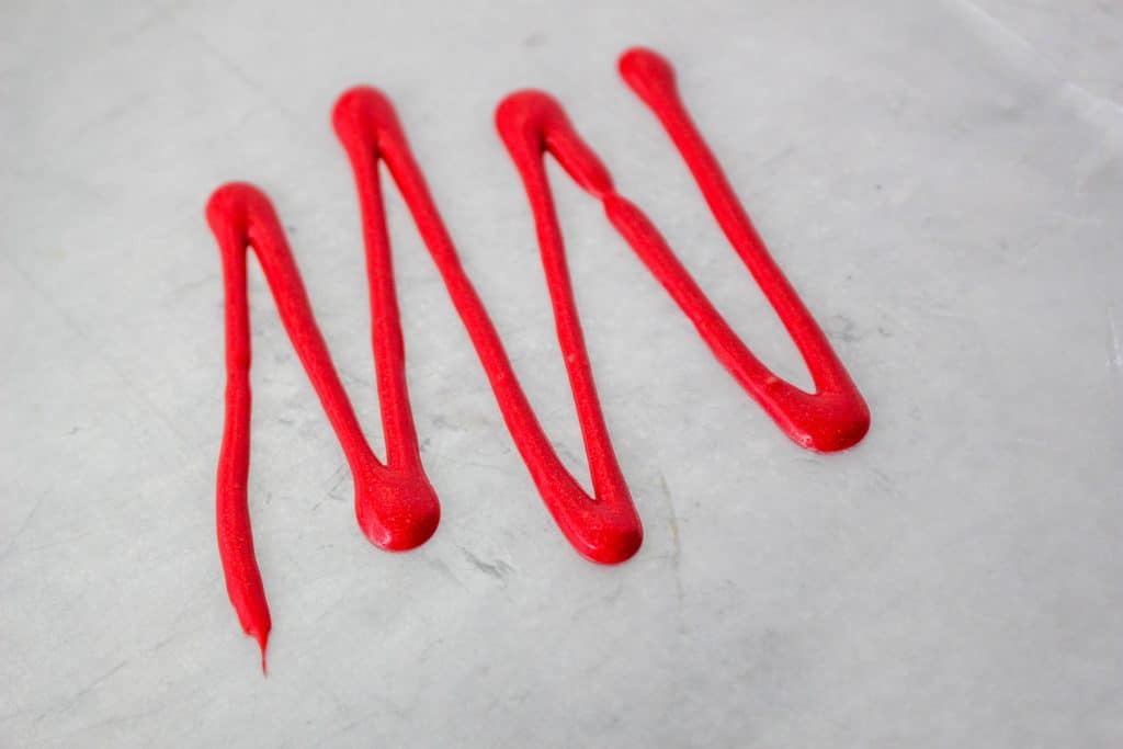 Little Debbie Christmas Tree Cake Dip (Easy No Bake Christmas Dessert) 11 red candy melt drizzle on parchment paper
