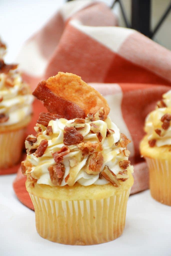 Maple Bacon Cupcakes with Whiskey Caramel Sauce 8 maple bourbon cupcake with a piece of bacon on top