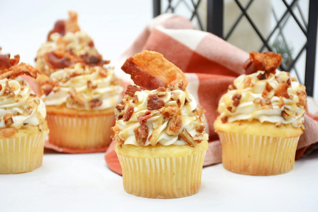 Maple Bacon Cupcakes with Whiskey Caramel Sauce 4 maple bourbon cupcakes with pieces of bacon on top