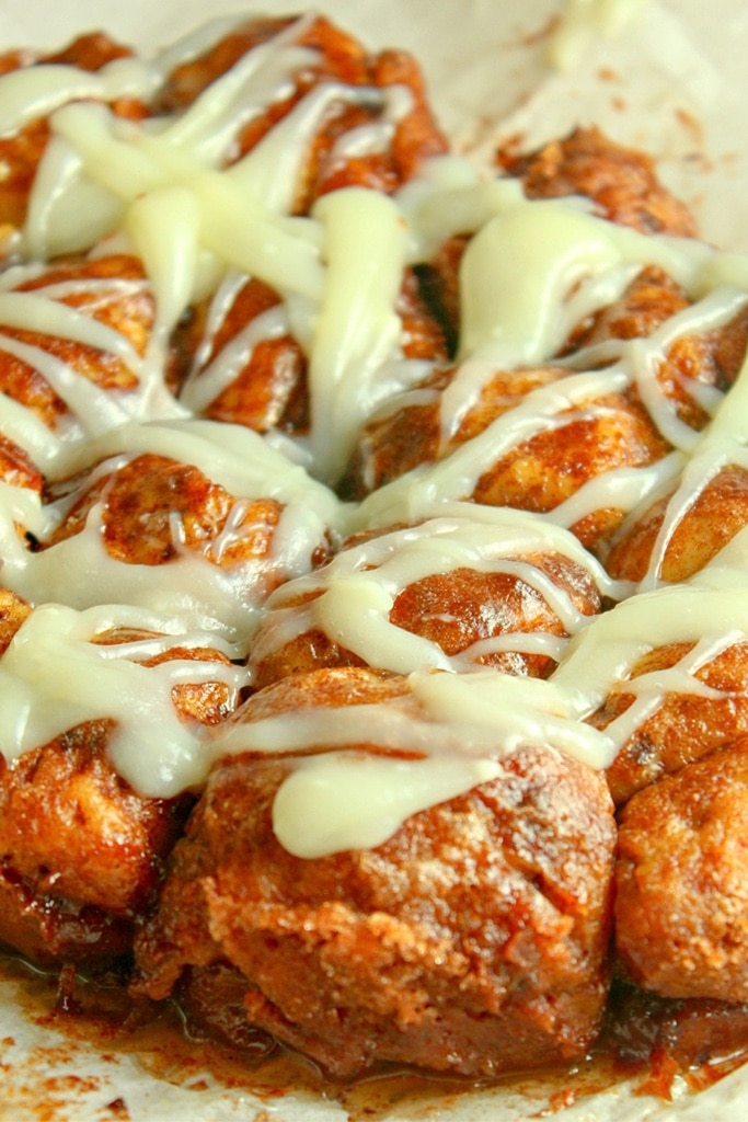 pumpkin monkey bread with cream cheese icing drizzled over 