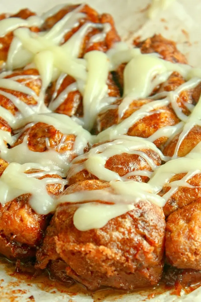 pumpkin monkey bread with cream cheese icing drizzled over 