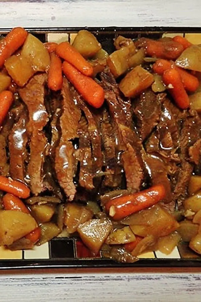 slow cooker brisket on pan with carrots and potatoes 
