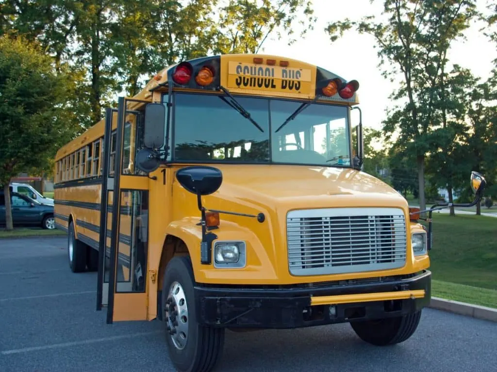 yellow school bus in parking lot with doors open