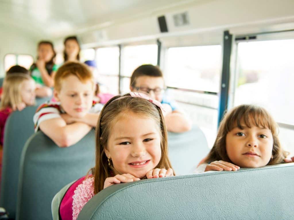 Christmas Gift Ideas for Bus Drivers 2 Kids on school bus looking over the back of the seat