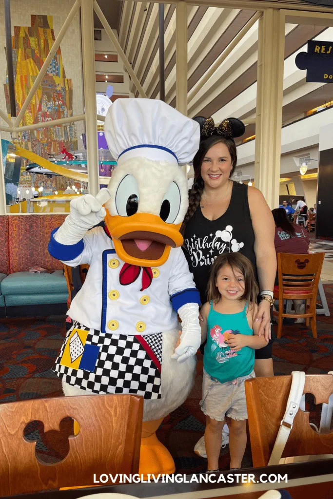 mom and daughter with Donald Duck enjoying disney character dining