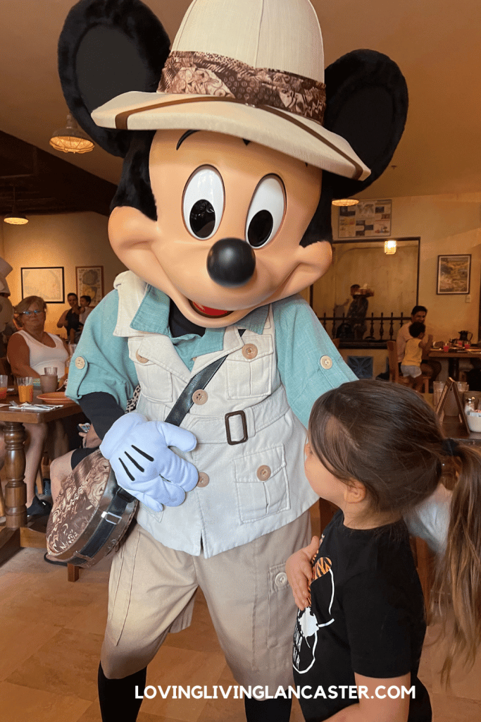 girl with Mickey Mouse at a disney character dining restaurant
