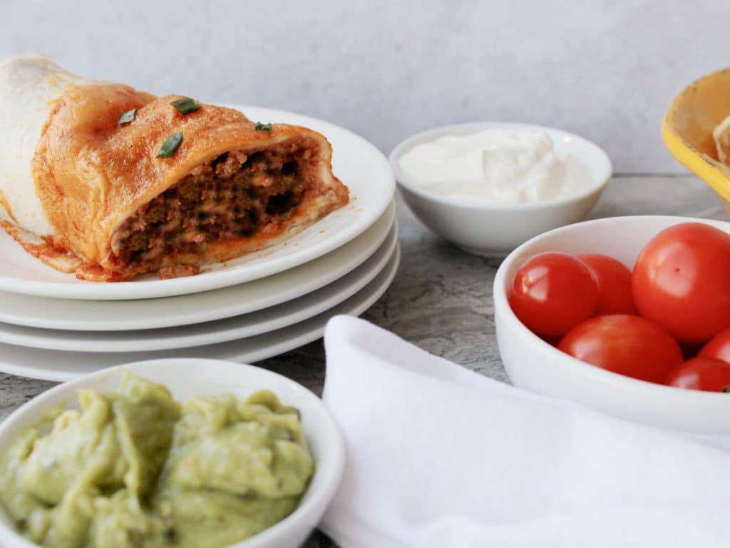 Taco Bell Enchrito Copycat Recipe 3 Taco Bell copycat enchirito on a white plate and ingredients around it