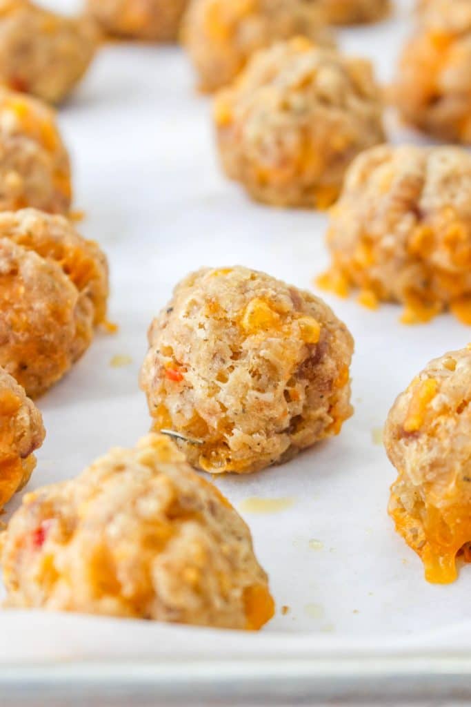 close up of raw Pimento Cheese Sausage Balls on parchment paper on baking tray