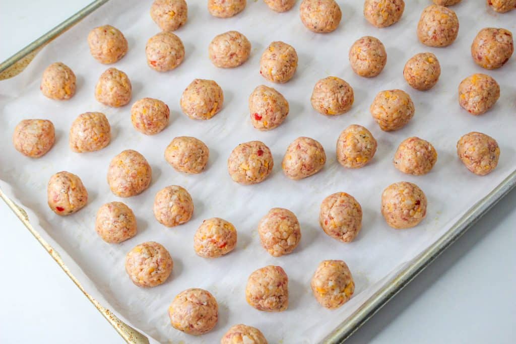 raw Pimento Cheese Sausage Balls on parchment paper on baking sheet