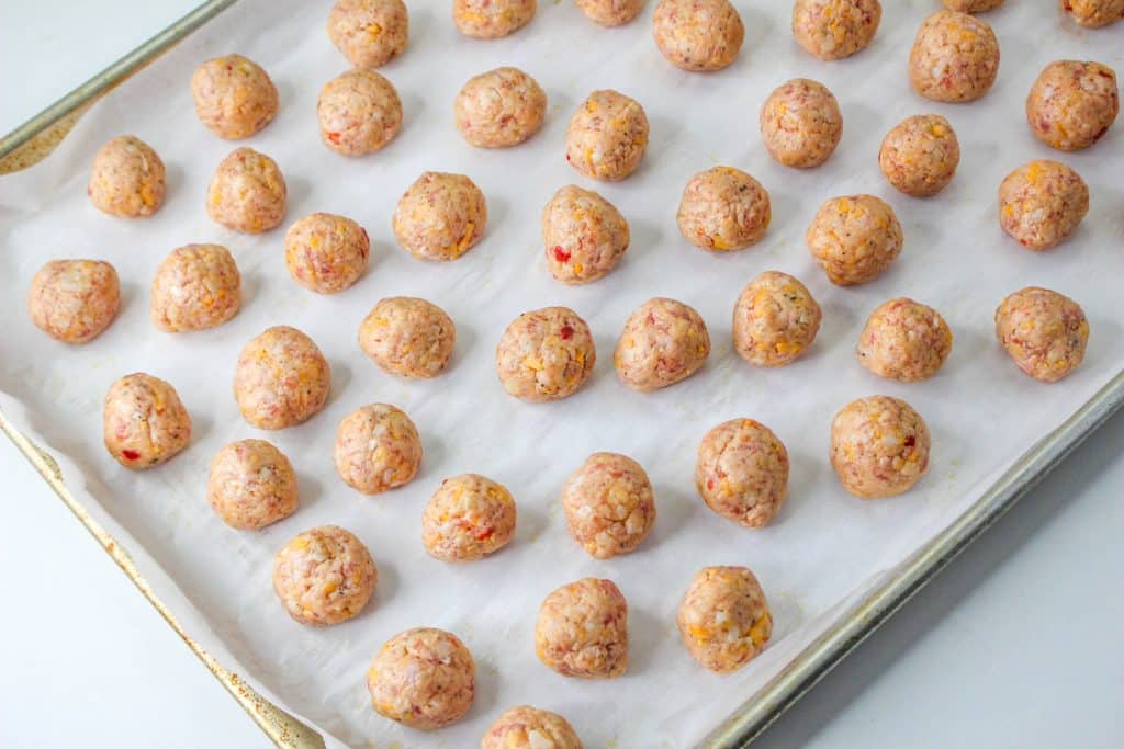 3 Ingredient Sausage Cheese Balls with Pimento Cheese 18 raw Pimento Cheese Sausage Balls on parchment paper on baking sheet