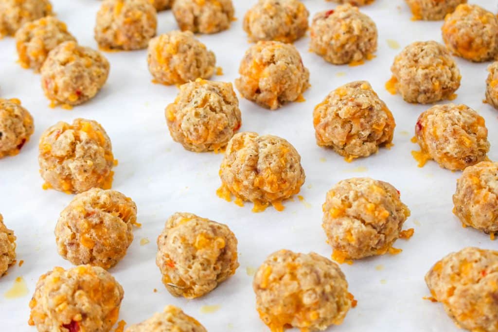 3 Ingredient Sausage Cheese Balls with Pimento Cheese 19 close up of raw Pimento Cheese Sausage Balls on parchment paper on baking tray
