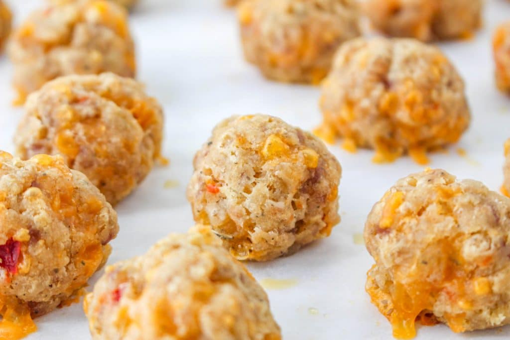 3 Ingredient Sausage Cheese Balls with Pimento Cheese 21 close up of raw Pimento Cheese Sausage Balls on parchment paper on baking sheet