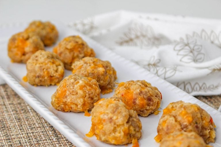 Overhead view of Pimento Cheese Sausage Balls on white rectangle serving tray.