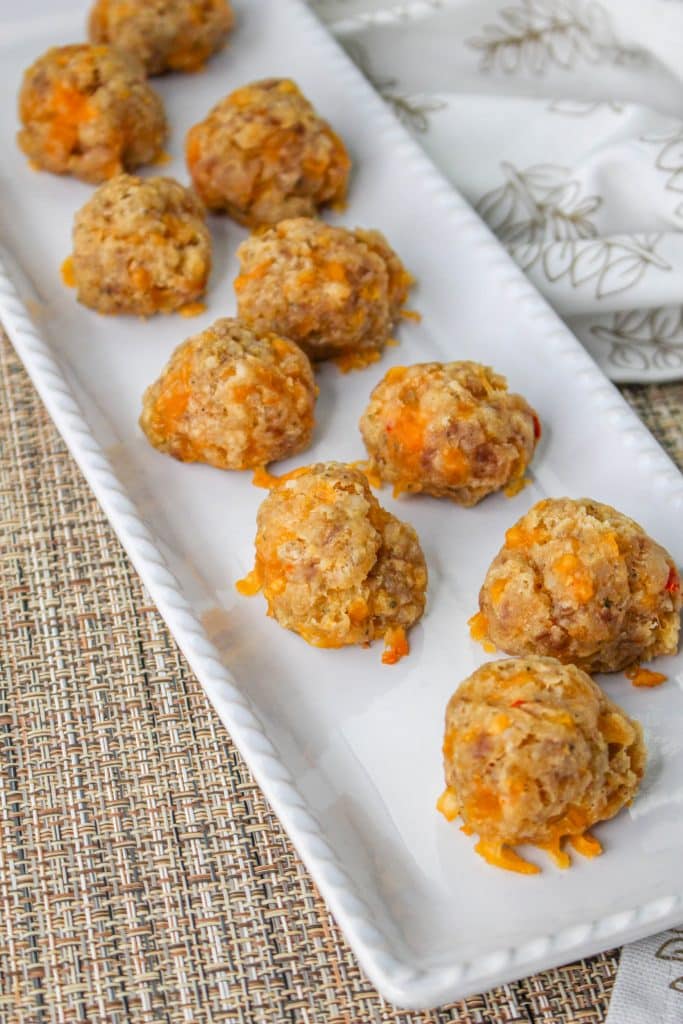 3 Ingredient Sausage Cheese Balls with Pimento Cheese 5 overhead view of Pimento Cheese Sausage Balls on white rectangle serving tray
