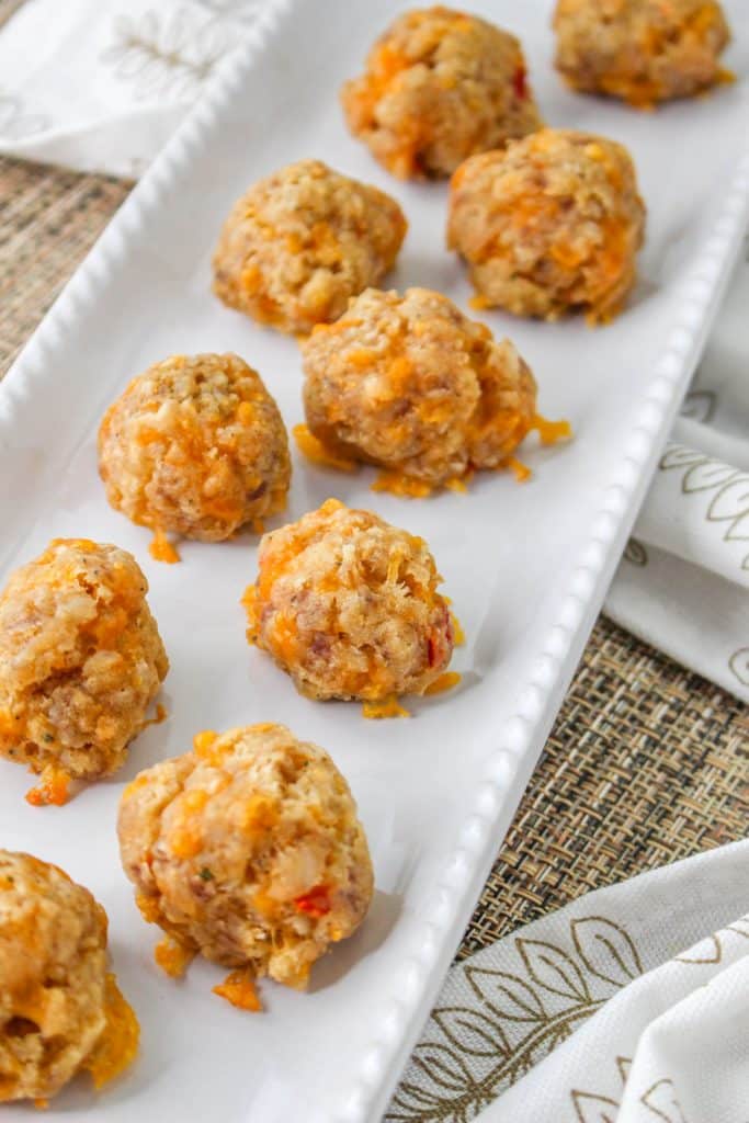 3 Ingredient Sausage Cheese Balls with Pimento Cheese 9 overhead view of Pimento Cheese Sausage Balls on white rectangle serving tray