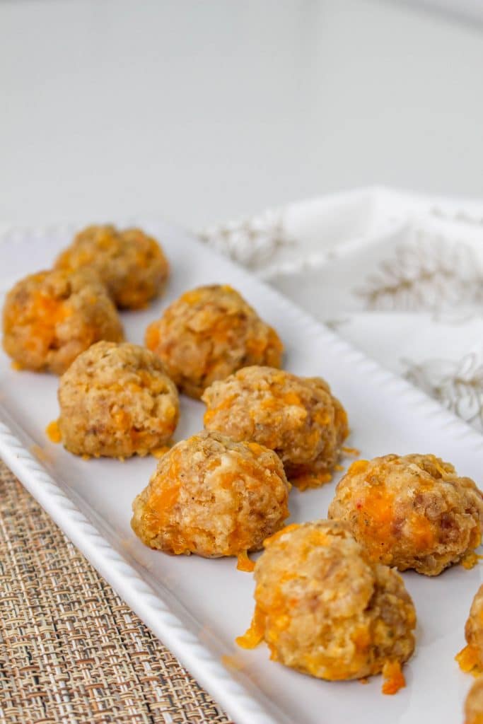 3 Ingredient Sausage Cheese Balls with Pimento Cheese 23 overhead view of Pimento Cheese Sausage Balls on white rectangle serving tray