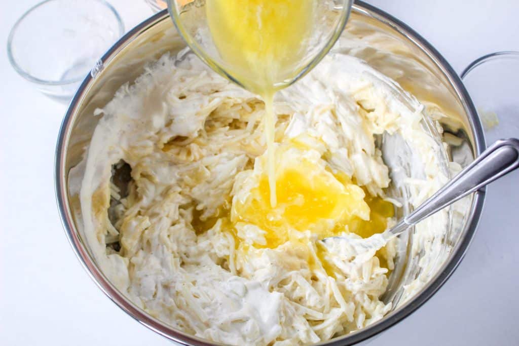 Slow Cooker Cracker Barrel Cheesy Hash Brown Casserole 13 Slow Cooker Cracker Barrel Cheesy Hash Brown Casserole ingredients mixed in bowl with butter getting poured in