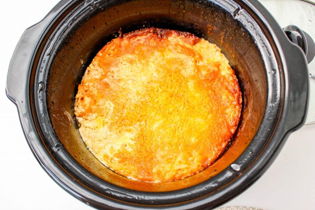 Slow Cooker Cracker Barrel Cheesy Hash Brown Casserole in crockpot with melted cheese on top