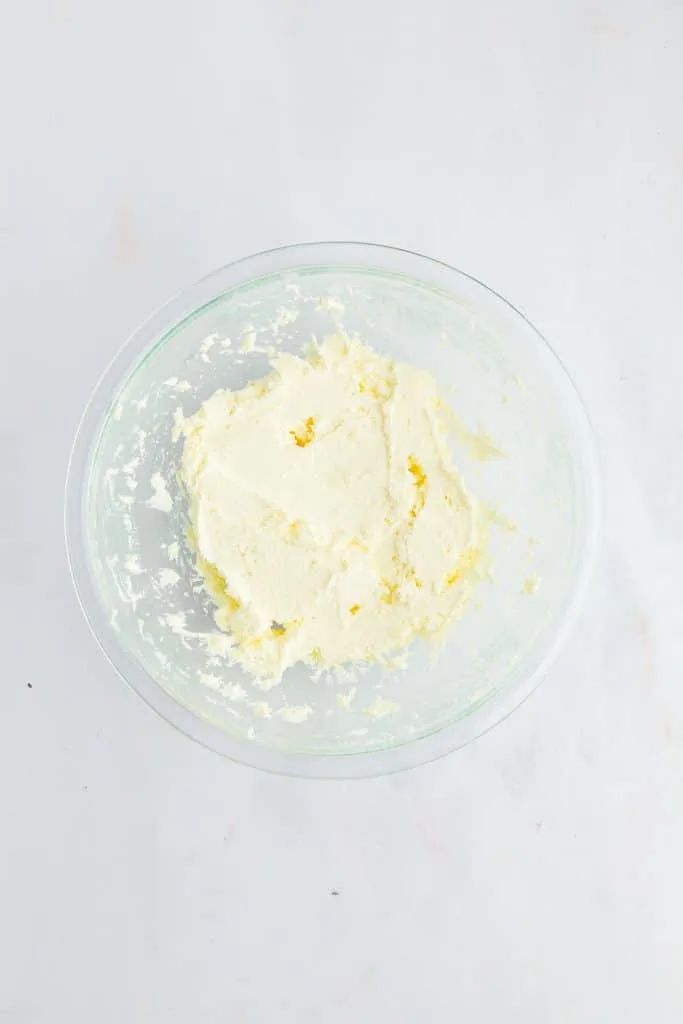 carrot cake cookie sandwich frosting in clear mixing bowl