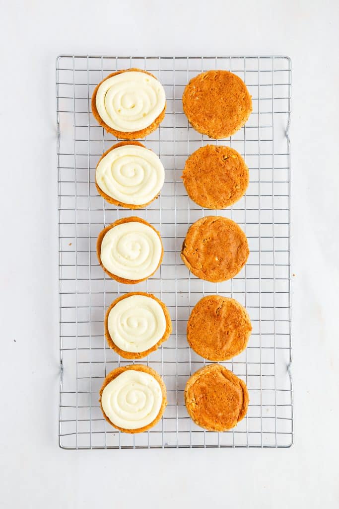 Carrot Cake Cookies 30 Carrot cake cookies on wire cooking rack half with frosting.