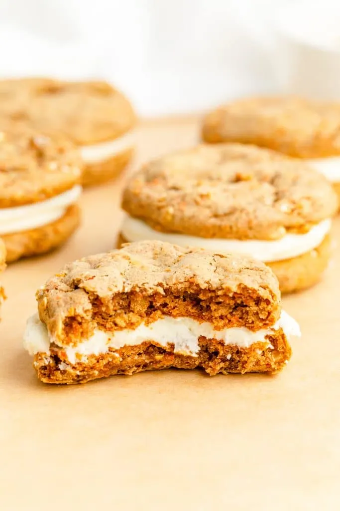 close up of center of Carrot Cake Mix Cookie Sandwiches with frosting with more cookies in background