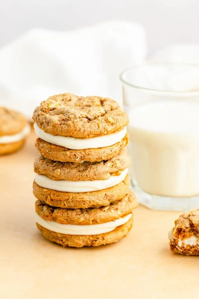stack of Carrot Cake Mix Cookie Sandwiches with glass of milk in background