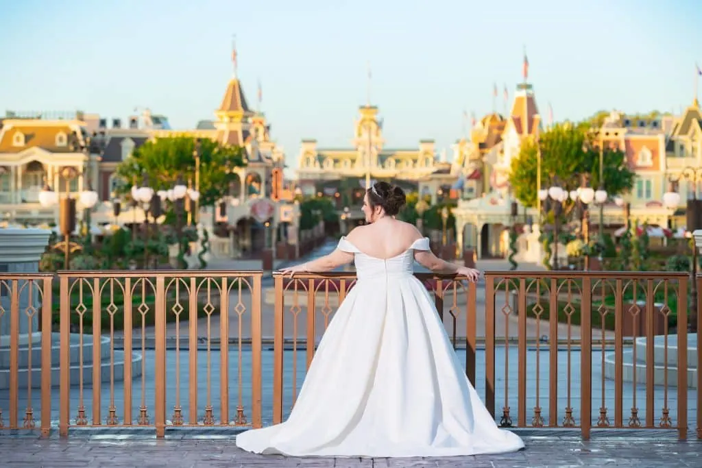 Bride in wedding dress in Magic Kingdom in front of castle looking down Main Street USA