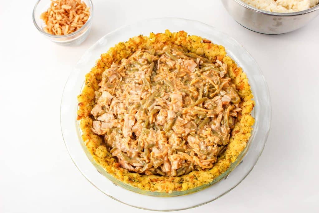 Turkey pot pie topped with crunchy French onions on a white countertop.