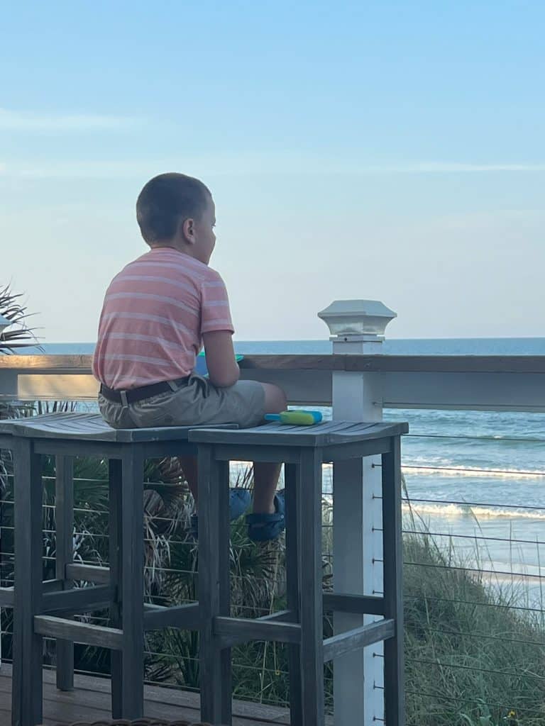 10 Free Things to do in St. Augustine With Kids (2025) 2 Child sitting on stool overlooking St Augustine Beach