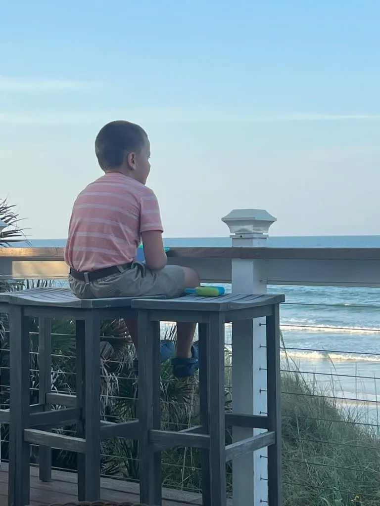 Child sitting on stool overlooking St Augustine Beach 