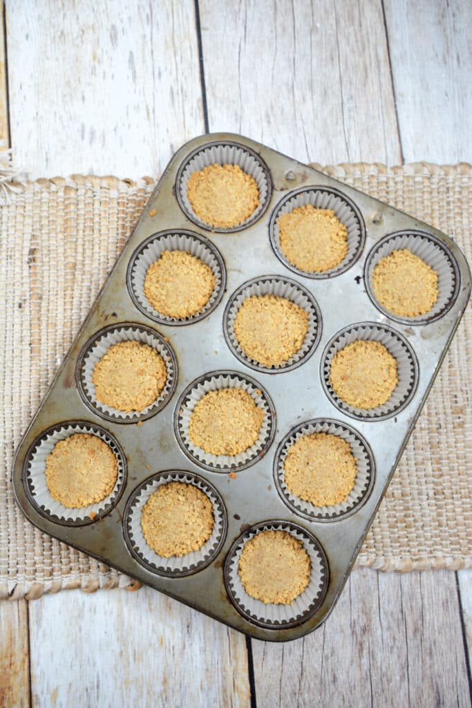 Mini Key Lime Cheesecakes 5 graham cracker crust pressed into cupcake baking tin.