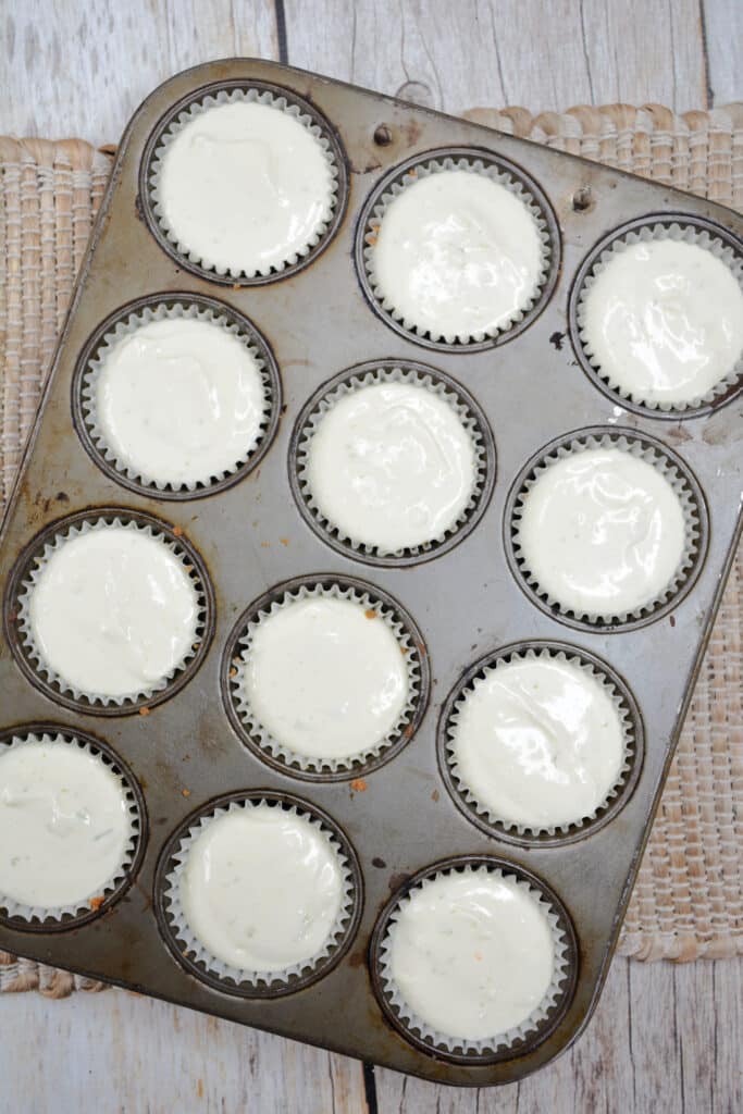 Mini Key Lime Cheesecakes 7 key lime cheesecake mixture in muffin tins prior to baking.